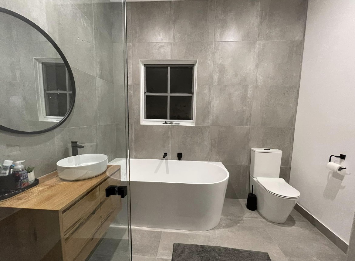 Finished bathroom with freestanding bath, vanity and toilet